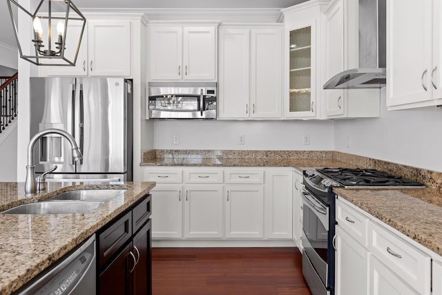 kitchen with stainless steel appliances, white cabinets, glass insert cabinets, and wall chimney range hood