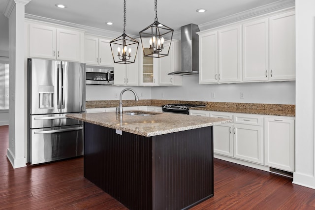 kitchen with white cabinets, an island with sink, wall chimney exhaust hood, stainless steel appliances, and a sink