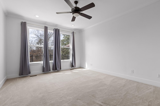 empty room featuring ornamental molding, light colored carpet, and baseboards