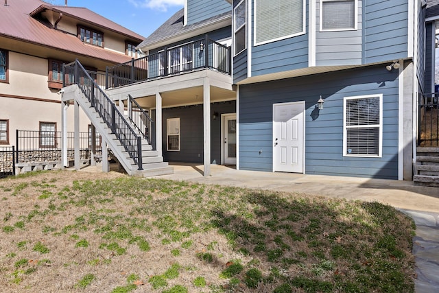 back of property featuring stairs, a patio, and a yard