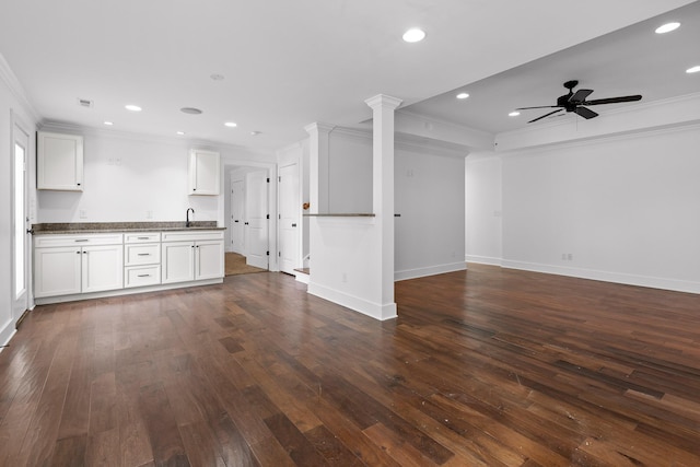 interior space featuring dark countertops, open floor plan, white cabinets, and crown molding