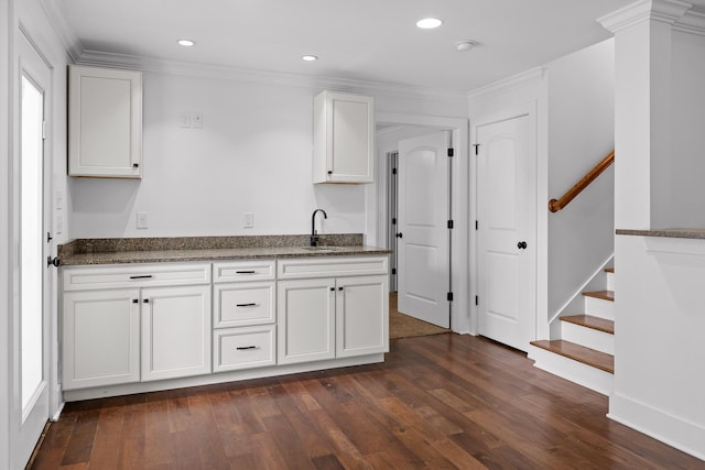 kitchen featuring recessed lighting, dark wood-type flooring, a sink, white cabinetry, and ornamental molding