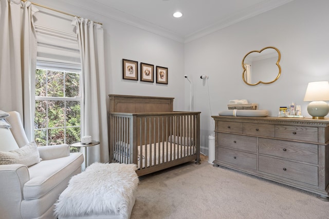 bedroom with a crib, recessed lighting, light colored carpet, and crown molding