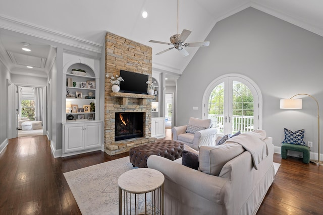 living room with attic access, a ceiling fan, dark wood-style floors, and a fireplace