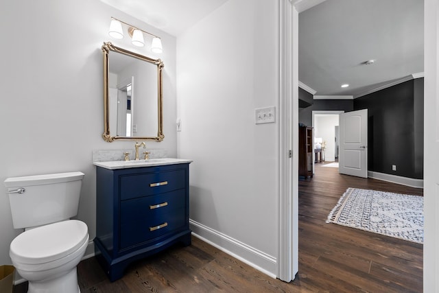 bathroom featuring wood finished floors, toilet, baseboards, and ornamental molding