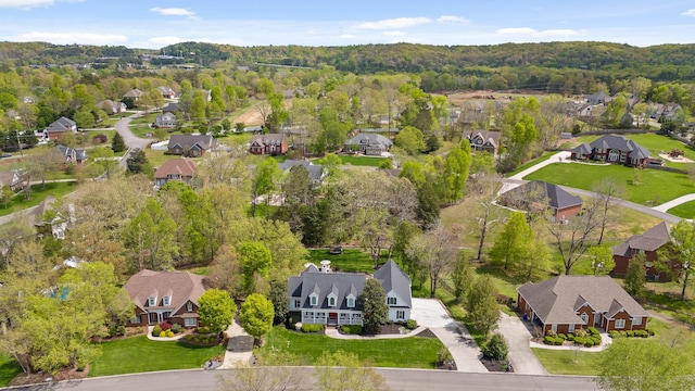 drone / aerial view with a wooded view and a residential view
