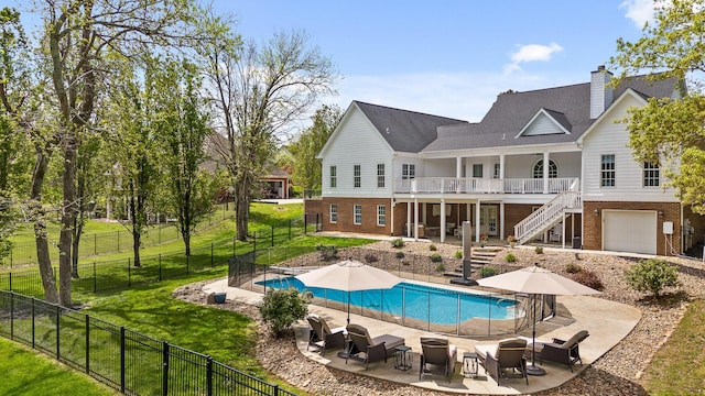 back of house featuring a lawn, a fenced backyard, a fenced in pool, brick siding, and stairs