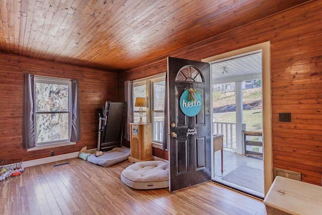 entrance foyer with wooden ceiling, light wood-style flooring, visible vents, and baseboards