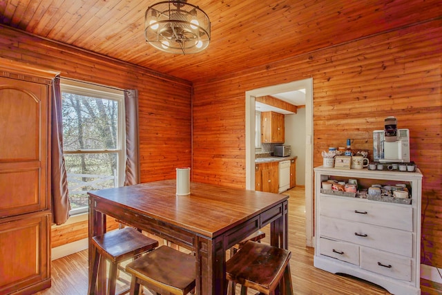 dining room with wood ceiling, light wood-style flooring, and an inviting chandelier