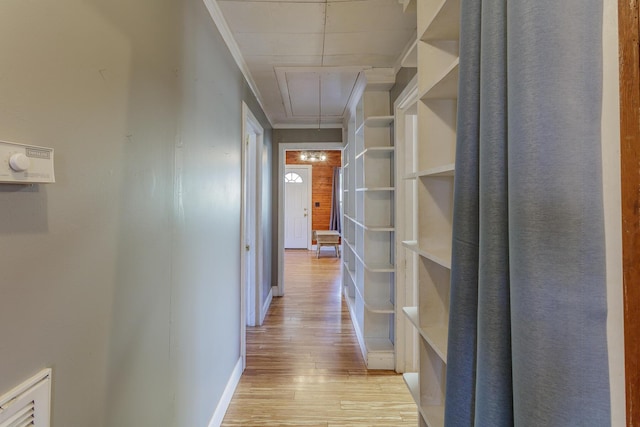 hallway with light wood finished floors, attic access, visible vents, and baseboards