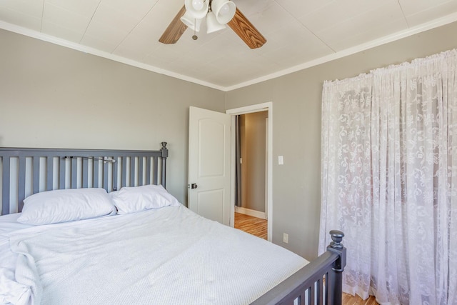 bedroom featuring baseboards, ceiling fan, ornamental molding, and wood finished floors