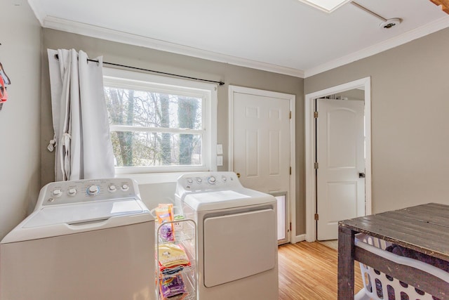 laundry area with laundry area, ornamental molding, light wood-style floors, and independent washer and dryer