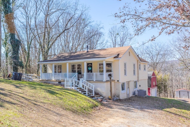 view of front of property with covered porch, driveway, a front lawn, and central air condition unit