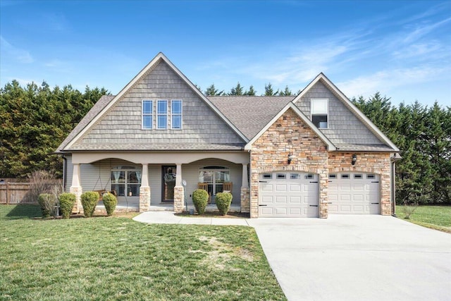 craftsman house featuring a porch, fence, stone siding, driveway, and a front lawn