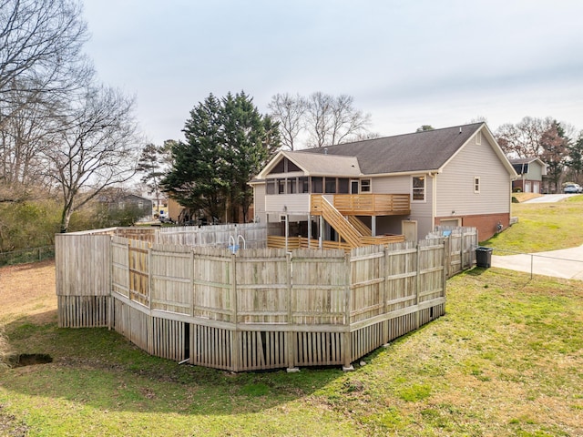 back of house featuring stairway, fence, and a yard