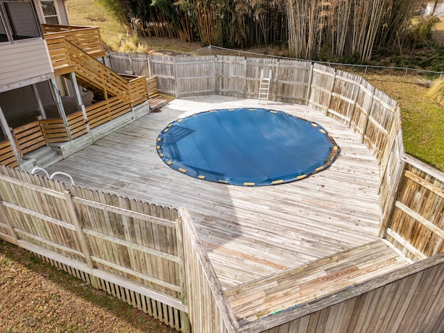 view of pool with a fenced in pool, a fenced backyard, and a wooden deck