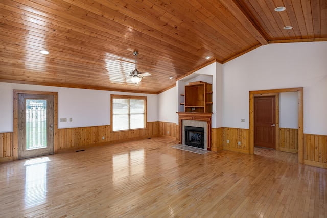 unfurnished living room with wooden ceiling, a wainscoted wall, and vaulted ceiling with beams