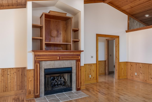 unfurnished living room with wooden ceiling, vaulted ceiling, and wainscoting