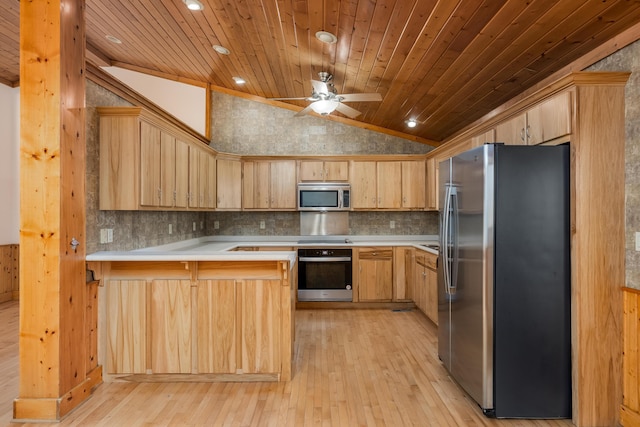 kitchen featuring a peninsula, stainless steel appliances, light countertops, and light brown cabinetry