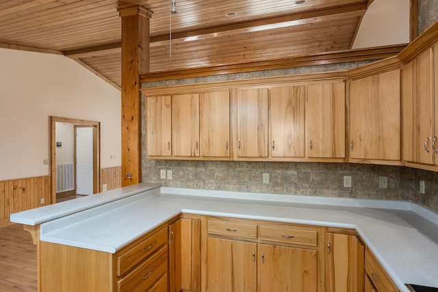 kitchen featuring a wainscoted wall, lofted ceiling, light countertops, wood ceiling, and a peninsula