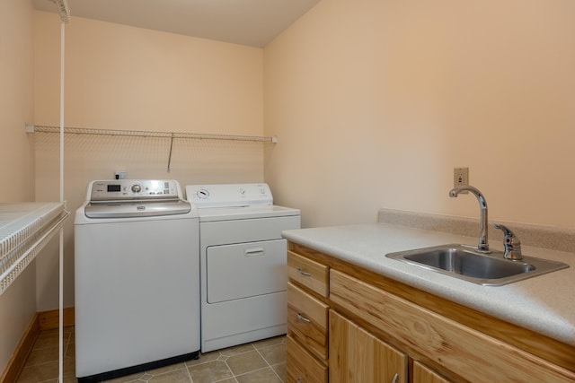 laundry area featuring washer and clothes dryer, light tile patterned flooring, and a sink