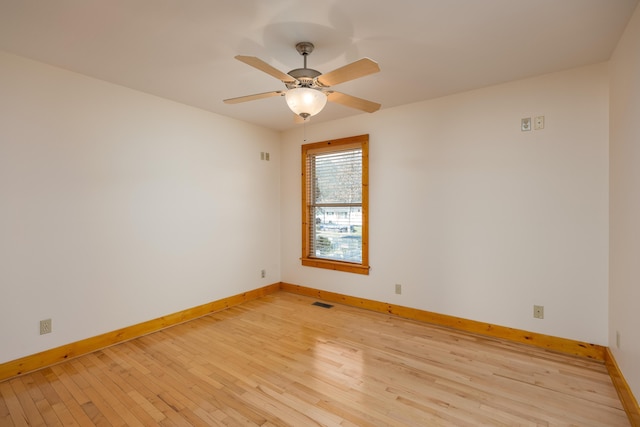 unfurnished room with visible vents, light wood-type flooring, a ceiling fan, and baseboards