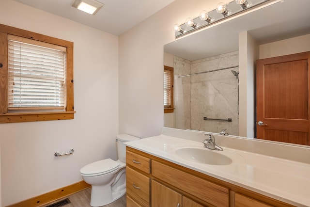 full bathroom with visible vents, toilet, vanity, baseboards, and walk in shower