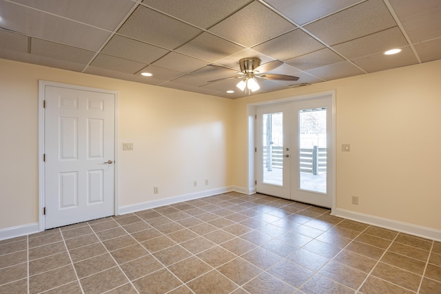 empty room with a paneled ceiling, baseboards, and french doors