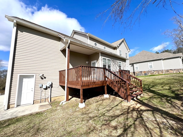 rear view of property with a deck and a lawn