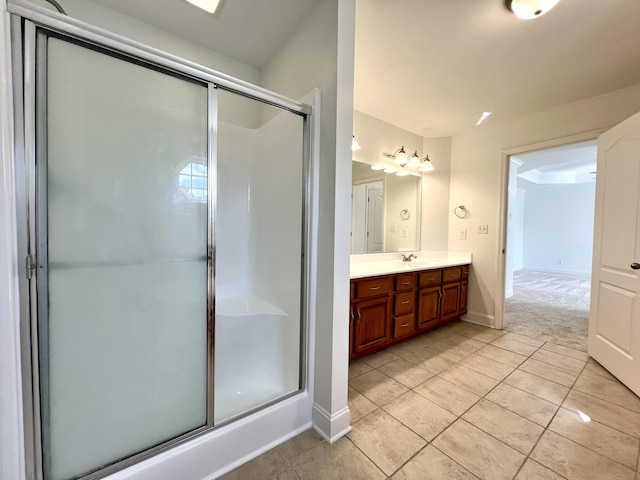 bathroom featuring baseboards, a shower stall, vanity, and tile patterned floors