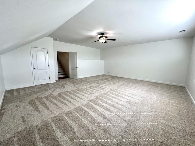 additional living space with a ceiling fan, visible vents, vaulted ceiling, baseboards, and carpet