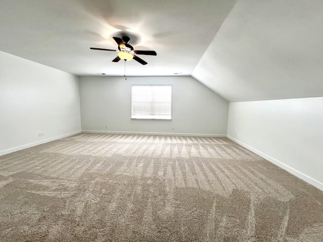 additional living space featuring vaulted ceiling, ceiling fan, carpet flooring, and baseboards