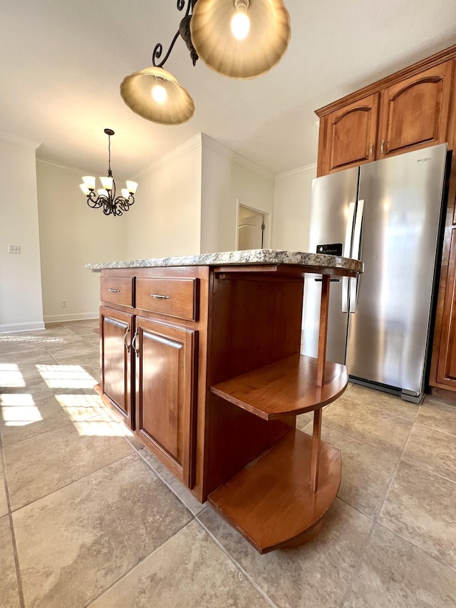 kitchen featuring light countertops, stainless steel fridge, decorative light fixtures, and brown cabinets