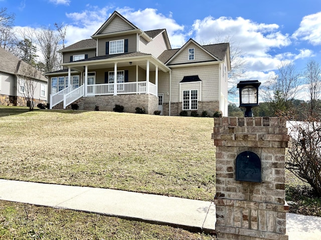 view of front of home with stone siding, a porch, and a front yard