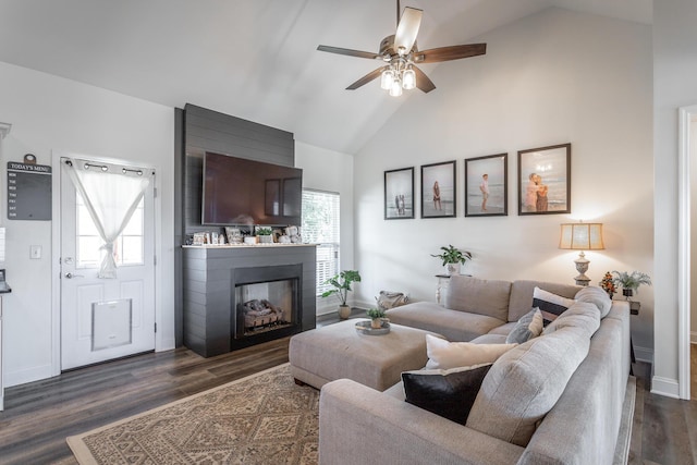 living room with a large fireplace, ceiling fan, dark wood-type flooring, and baseboards