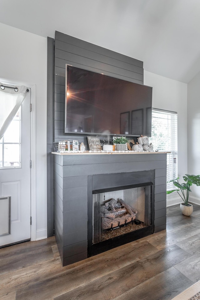 interior details featuring a fireplace, baseboards, and wood finished floors