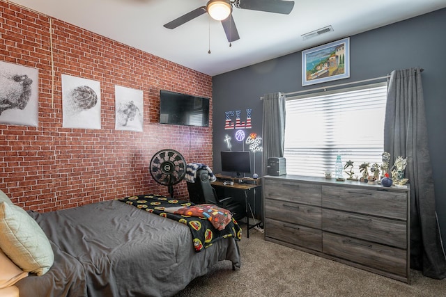 bedroom featuring light carpet, visible vents, brick wall, an accent wall, and ceiling fan