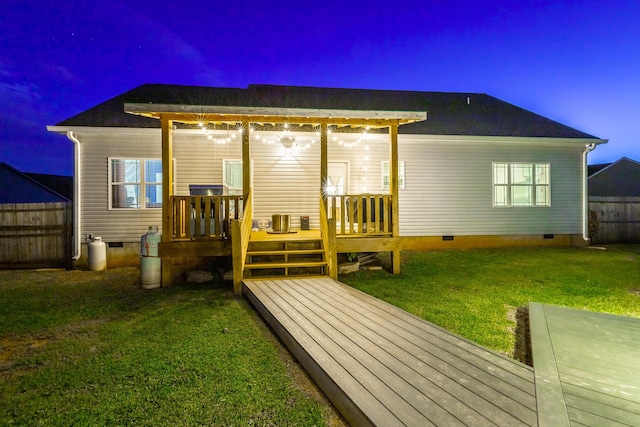 rear view of property featuring crawl space, fence, a lawn, and a wooden deck