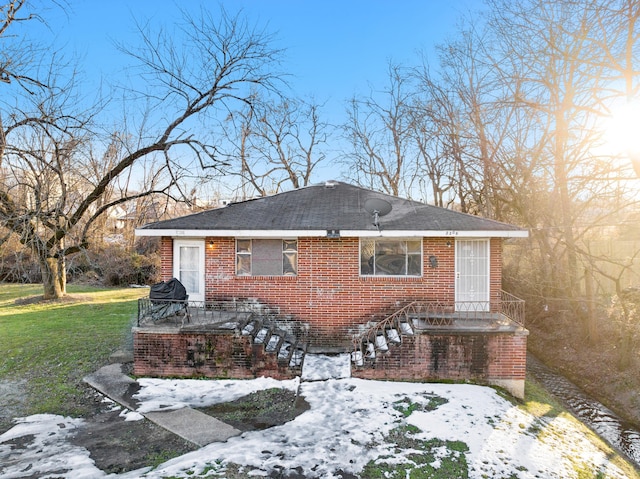 exterior space featuring a lawn and brick siding