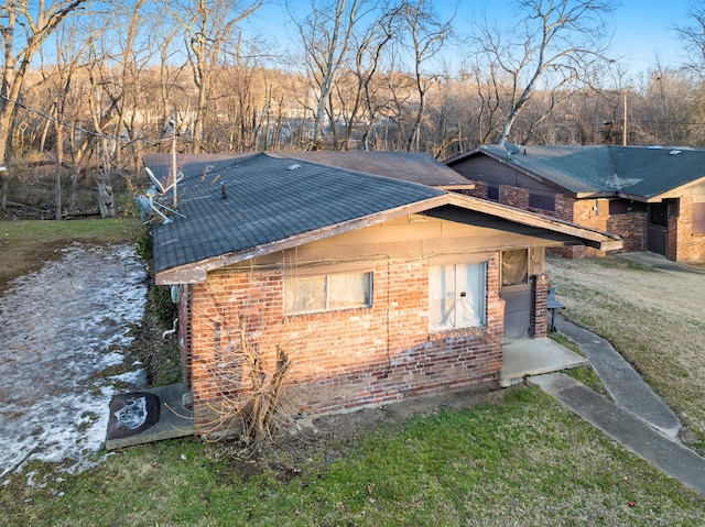 view of property exterior featuring a yard, a chimney, and brick siding