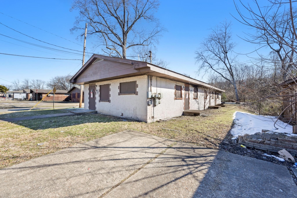 view of property exterior with a lawn and stucco siding