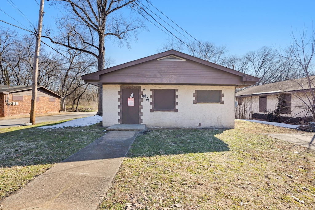 bungalow-style home featuring a front lawn