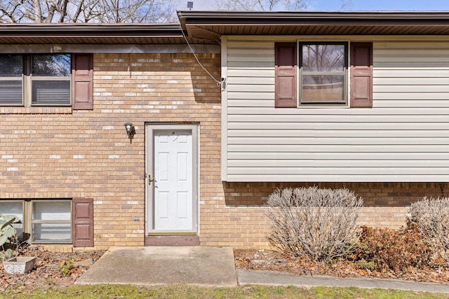 entrance to property featuring brick siding