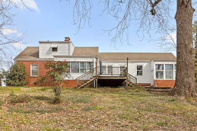 back of house with brick siding, a chimney, stairs, and a sunroom