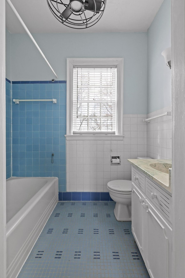 full bathroom with toilet, shower / bathing tub combination, tile walls, tile patterned flooring, and vanity