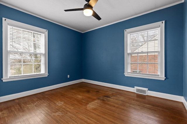 empty room featuring visible vents, baseboards, ornamental molding, a ceiling fan, and wood-type flooring