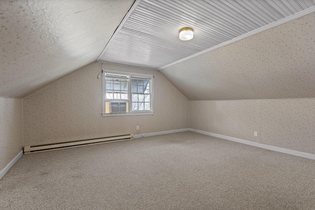 additional living space with a baseboard heating unit, lofted ceiling, carpet, and baseboards