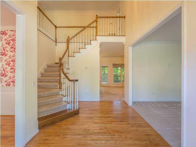 foyer entrance featuring a towering ceiling, stairway, and wood finished floors