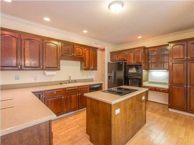 kitchen featuring a center island, light countertops, ornamental molding, light wood-type flooring, and black appliances