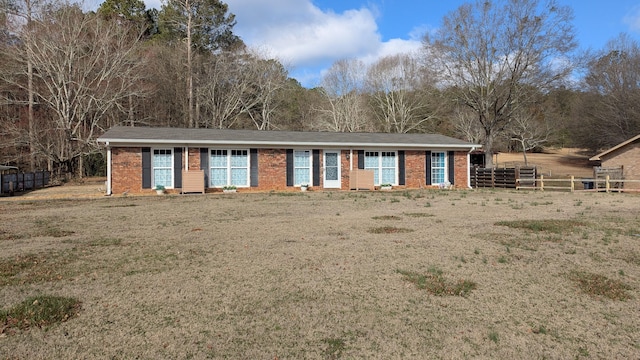 ranch-style house with brick siding, a front yard, and fence